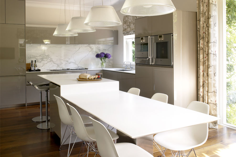 Bespoke kitchen design with matt lacquer cabinets, marble splashback and contemporary glass pendants.
