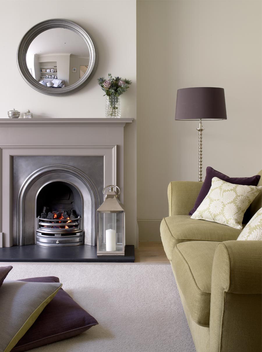 Relaxed family room scheme with lime green sofa and twisted chrome floor lamp beside painted fire surround.
